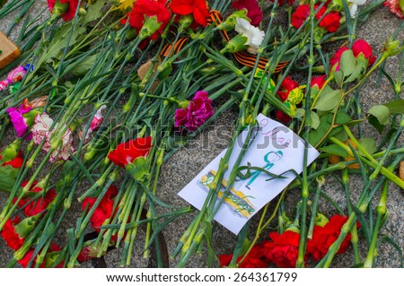 Russia, St. Petersburg - MAY 9: day of victory. the memory of soldiers in Great Patriotic War ( World War II ). 2014.  Postcard from the child at the grave of a soldier in honor of Victory Day
