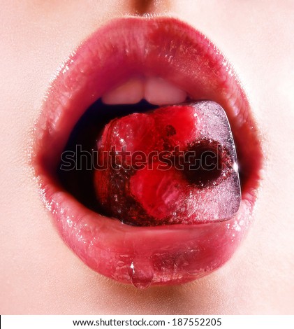 Super sexy female open mouth hold ice cube with strawberry and raspberries inside with drop on lower lip