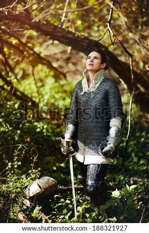 beautiful short haired girl in a chain armour with sword looking up to the light (art photo project \