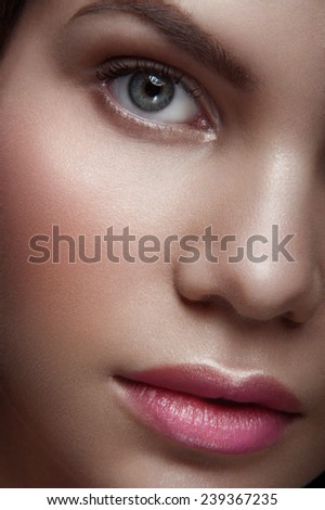 Close up portrait of beauty nude young lady with green eyes, natural make-up and natural lipstick, withhead to the right looking at you on dark background