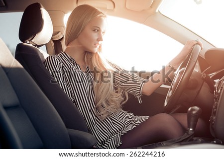 Blondie young girl at the wheel of sport car