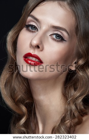 Portrait of beautiful young women with red lips, wavy hair, black eyeliner. Beauty. Studio shot. Black background.