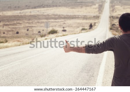 Man Hitchhiking on a Country Road