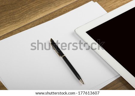 empty tablet pc and notebook with pen on the office desk