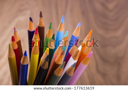 Color pencils in arrange in color wheel colors on wood background