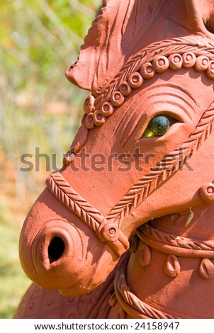 A terracotta horse figure in a garden