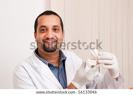 An Indian / Asian dentist with teeth mold