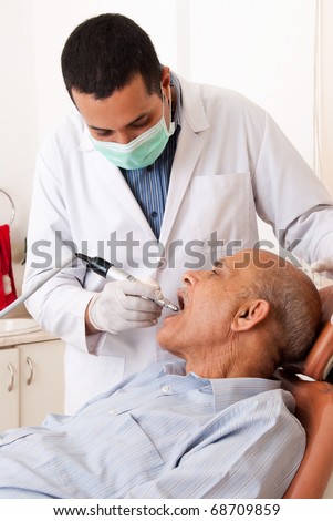 An Asian / Indian dentist with a patient
