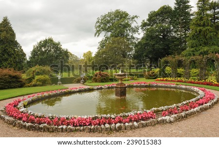 A Pond Surrounded by Begonias with A Fountain in the Middle in a Garden, near Barnstaple, in the County of Devon, England, UK
