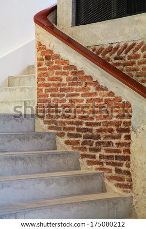The concrete stairway with banister made of bricks and wood