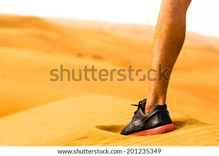 Close-up of sporty man leg/shoe standing alone in the desert. Fitness concept.
