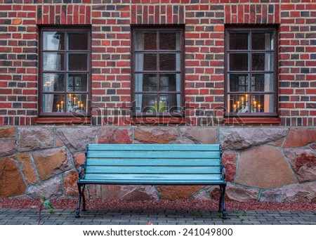 Bench on a background of a brick wall with windows