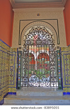 Ornate tile work in the gated entrance to a private Spanish courtyard garden in Seville.