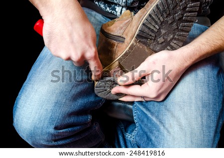 Shoemaker repairing a old pair of shoes heel