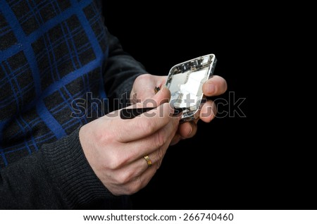 Cell phone repairman repairing broken and unscrewed cell phone isolated on black background