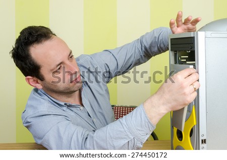Computer engineer working on a broken computer at the office. Isolated on retro striped green and yellow wallpaper.