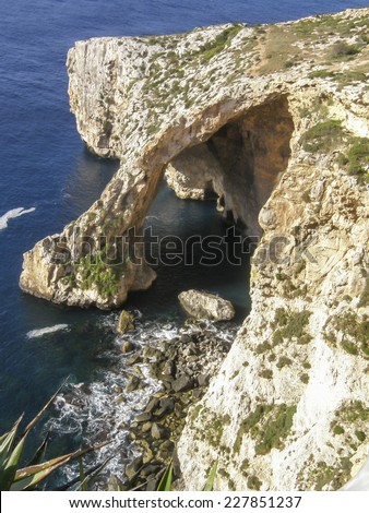 A natural stone arch reaches into the sea