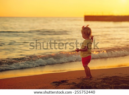 girl throwing stones into the sea