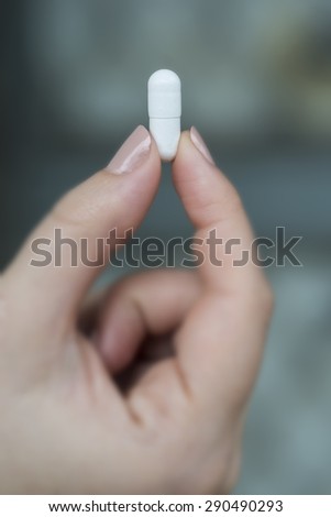 woman holding pill capsules