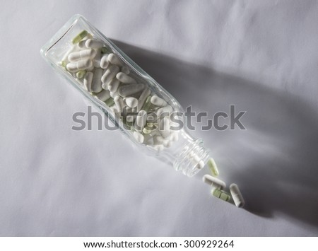 Pills and pill bottle on white background