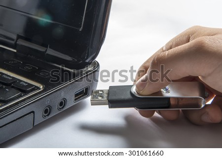 Hand inserting usb memory stick to laptop computer