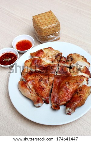 grilled chicken served with sweet  chili sauce, chili fish sauce and sticky rice in bamboo box