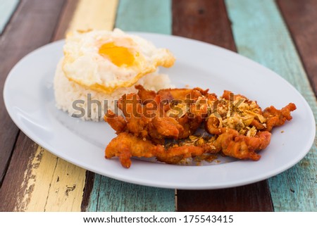 Steamed rice with deep fried pork with garlic served with a sunny-side-up egg
