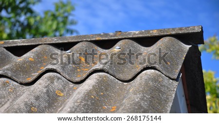 Blue sky over the dangerous asbestos old roof tiles able to use as background.