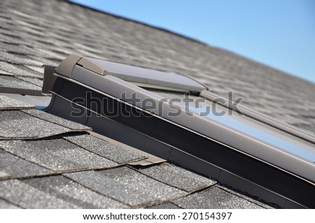 Roof window with closeup focus on bitumen-based waterproofing membrane areas.