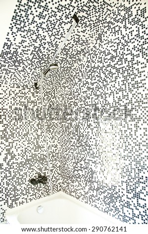 Black and white mosaic tile detail of a wall  bathroom decorated with tiles, interior decoration.