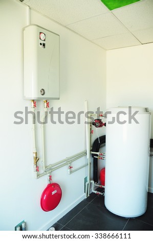 A domestic household boiler room with a new modern gas boiler, heating electric warm water system and pipes