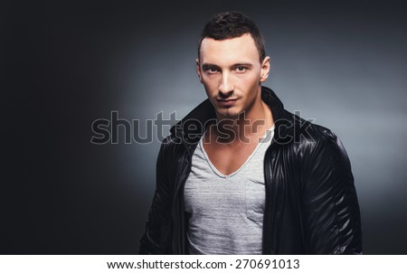 Fashion shot of a young handsome man in a leather jacket. Studio shot.