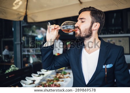 Elegant young man tasting wine