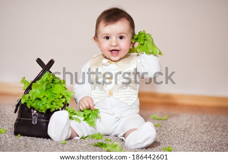 Baby with greens, salad in a bag