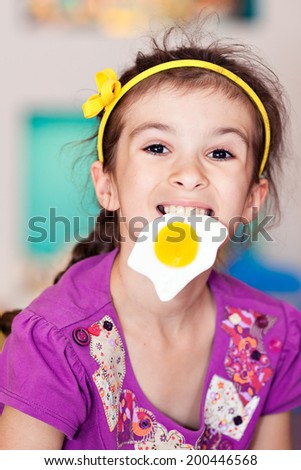 Child bites and eats fried egg