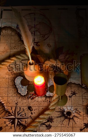Dark image Old map, a candle and the rope inkwell and quill