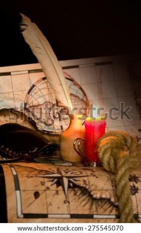 Dark image Old map, a candle and the rope inkwell
