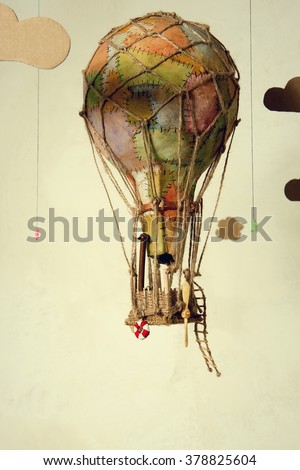 Strange steampunk balloon which flies between clouds and aims for the stars. On light background