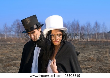 Girl in the white top hat and man in the black top hat in the field