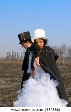 Girl in the white top hat and man in the black top hat in the field