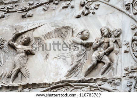 Bas-relief with a scene of exile from paradise of Adam and Eve on a facade of the Cathedral, Orviyeto, Italy
