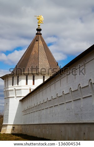 Monastic wall with a weather vane on an angular tower in the form of an angel blowing in a pipe, Serpukhov, Russia
