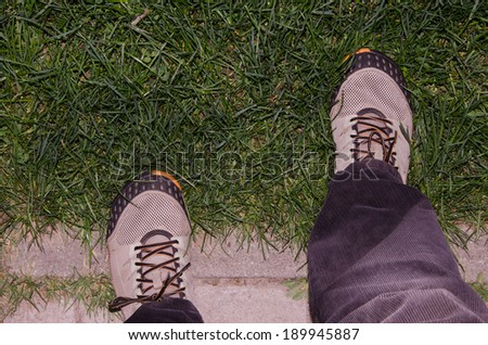 Step in sneakers with a stone on the grass
