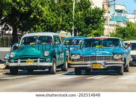 HAVANA, CUBA - DECEMBER 2, 2013: Old classic American cars the famous Malecon (Avenida de Maceo), where old cars are relic of Cuban revolution and still attracts many tourists.