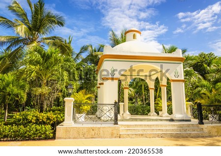 Wedding gazebo on one of Caribbean Islands, tall exotic palm trees and blue sky.