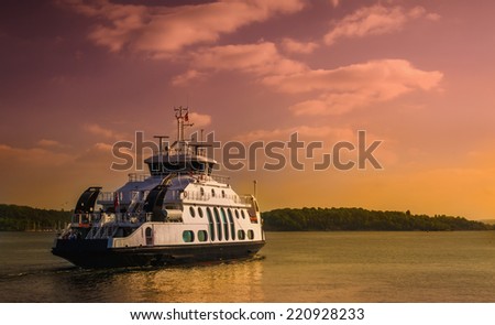 Small ferry cruising on sunset in Oslo fjord, Norway
