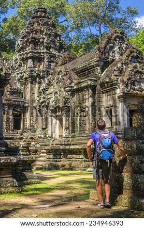 Young man admires amazing Angkor Wat Temple, Thommanon Temple, Siem Reap, Cambodia