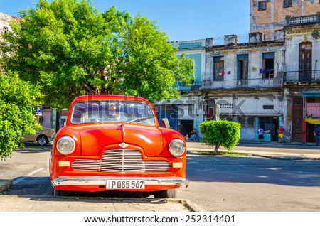 HAVANA, CUBA - DECEMBER 2, 2013: Classic American red car one of streets in Havana, where old cars bought before Cuban revolution are icon view of Cuba