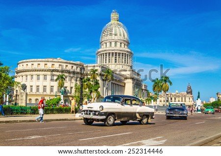 HAVANA, CUBA - DECEMBER 2, 2013: Old classic American car rides in front of the Capitol. Before a new law issued on October 2011, cubans could only trade cars that were on the road before 1959.