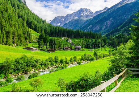 Beautiful alpine landscape with green meadows, alpine cottages and mountain peaks, Zillertal Alps, Austria